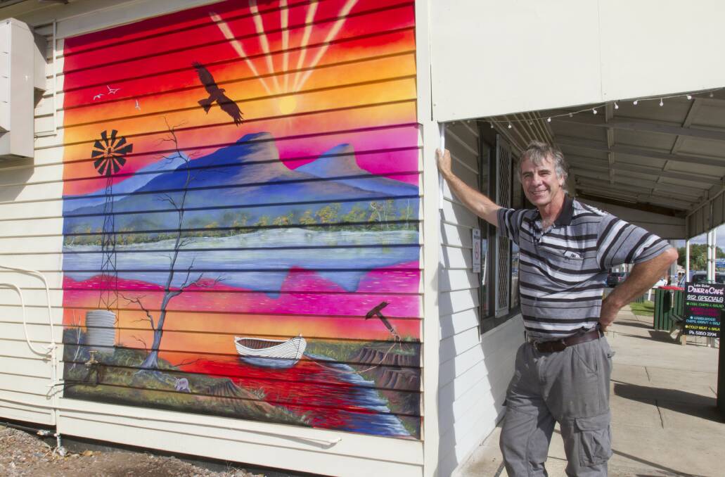 COLOURFUL: David McDonald, co-owner of the Lake Bolac Diner and Cafe, with the new mural by Gordon Wilson. Picture: PETER PICKERING. 