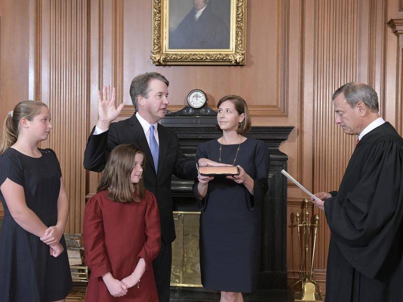 Brett Kavanaugh was quickly sworn in at the Supreme Court building, as protesters chanted outside.